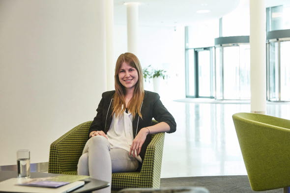 Picture shows a woman sitting on a chair in a lobby