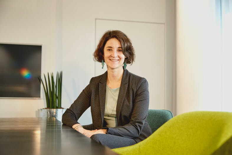 Picture of a woman sitting on a table in a meeting room