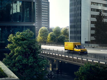 Bild eines fahrenden DHL Trucks in einer Stadt
