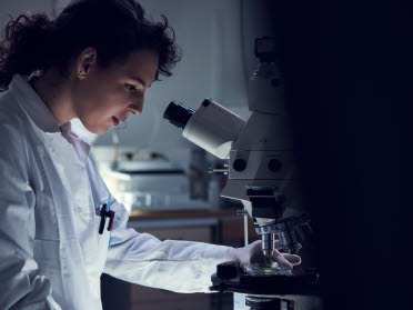 Woman in laboratory looking into a microscope