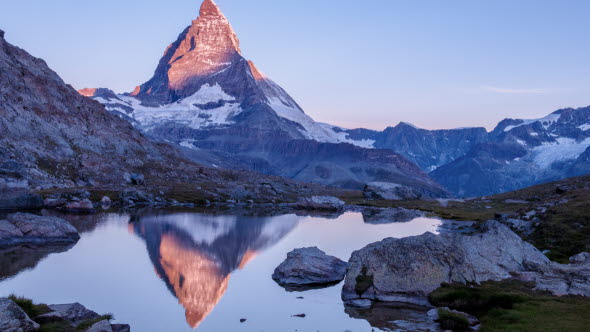 Sonnenaufgangsstimmung am Berg mit kleinem See davor