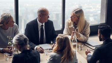 Menschen sitzen um einen Tisch und diskutieren