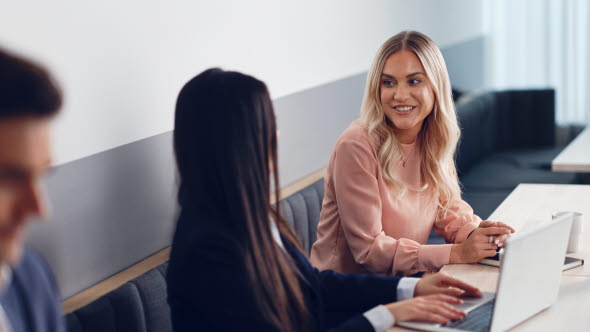 Eine Frau und ein Mann schauen auf einen Bildschirm.